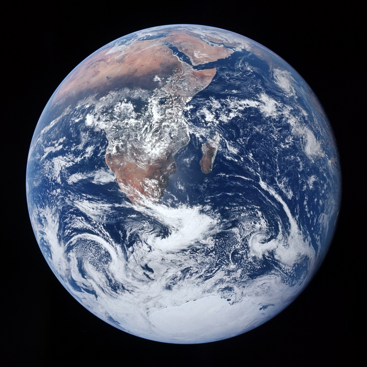 The Apollo 17 photograph of the whole Earth, Africa and Antarctica under swirling white cloud against black space
