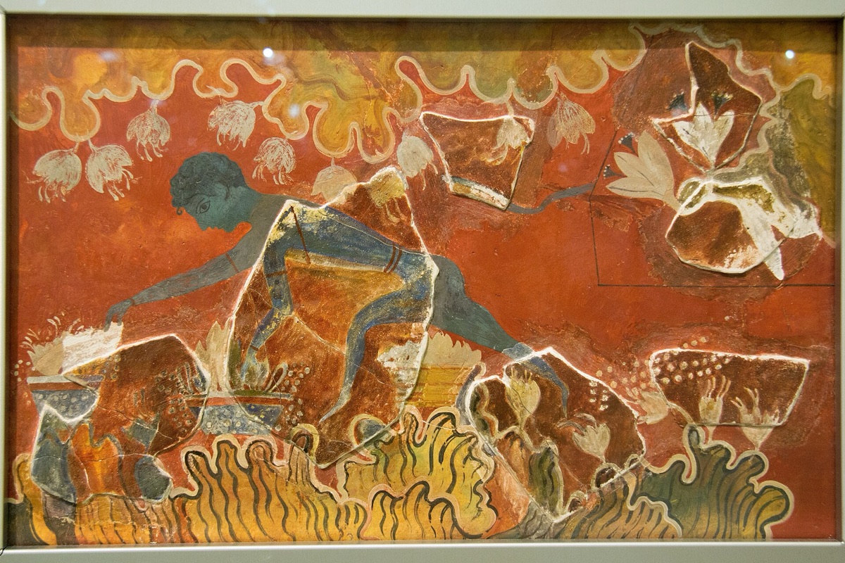 A Minoan fresco on a red ground: a blue figure gathering flowers among rocks, with large areas of flat modern plaster painted between the surviving fragments