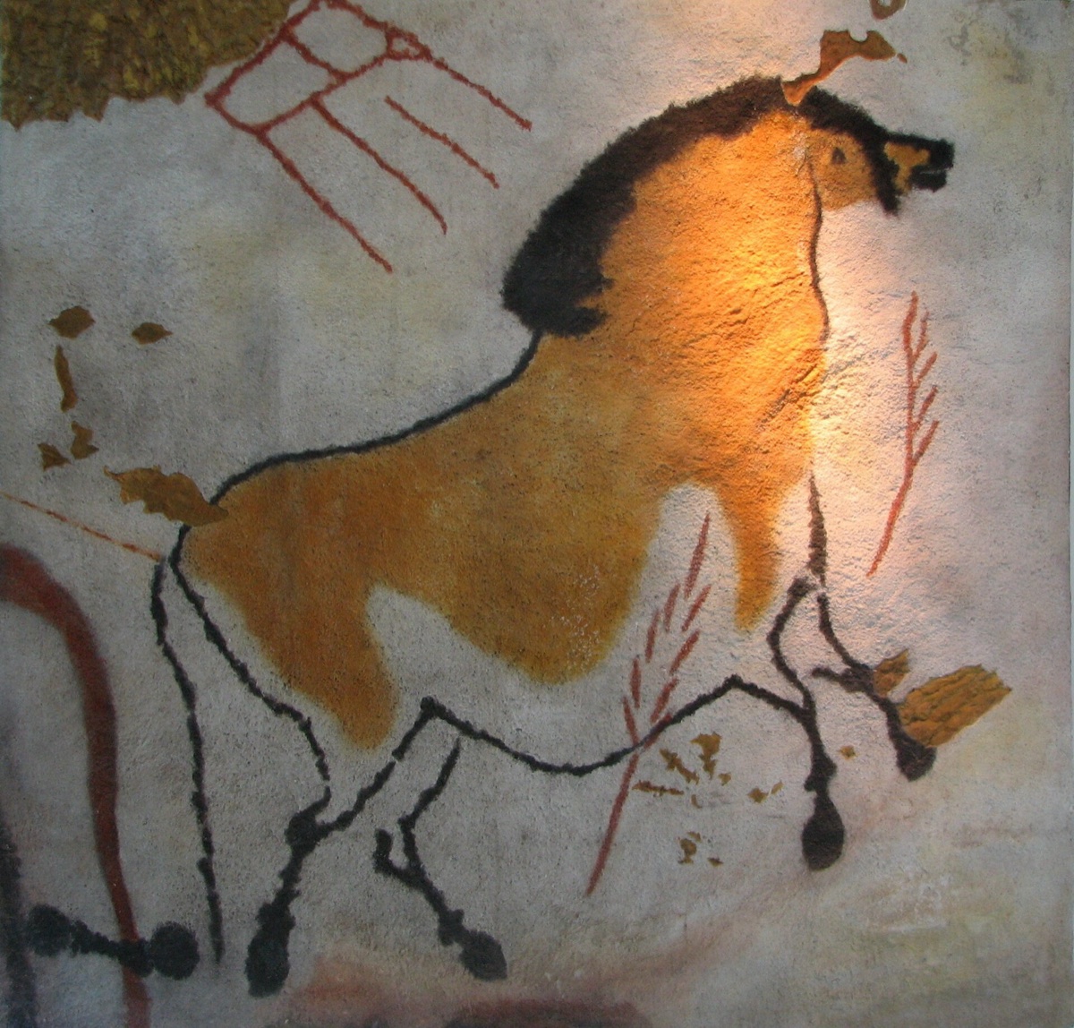 A painted horse in ochre and black on a pale curved surface, lit from above in a museum display